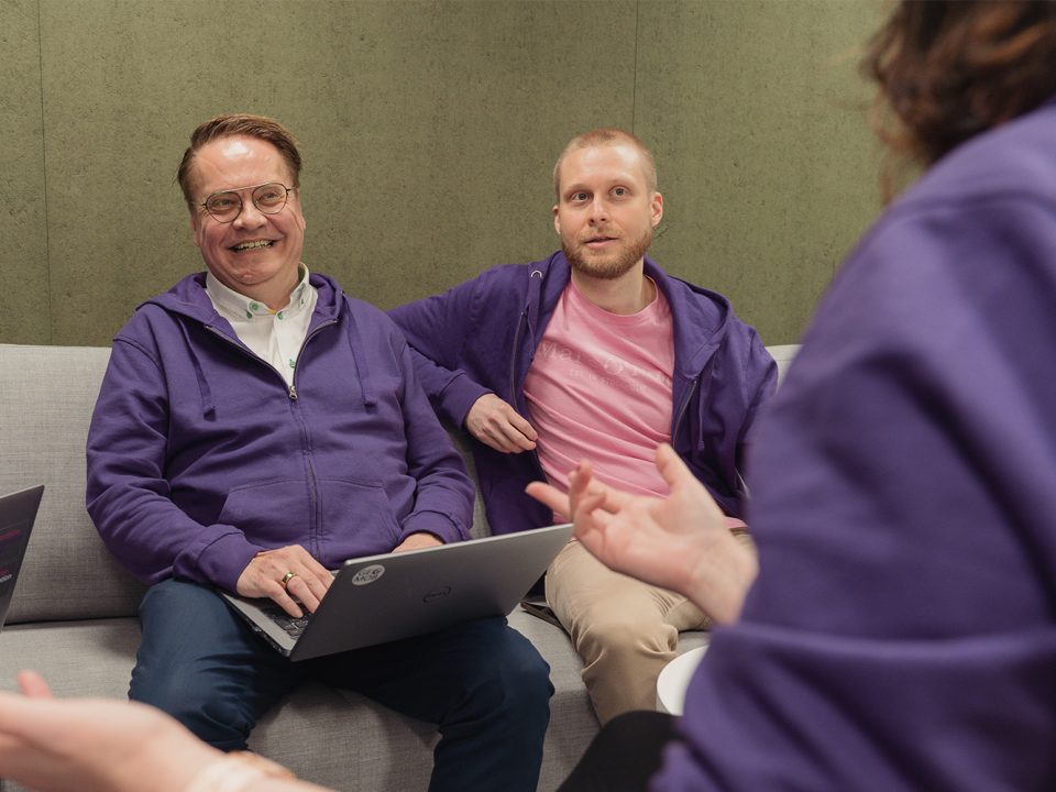 Antti Jakobsson & Joonas Jokela sitting on a couch and smiling.