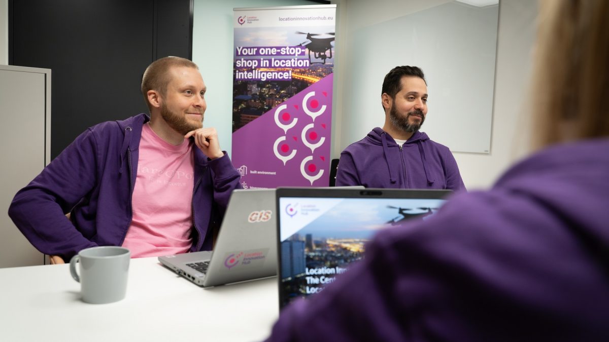 People from the LIH office chatting in a meeting room wearing purple hoodies.