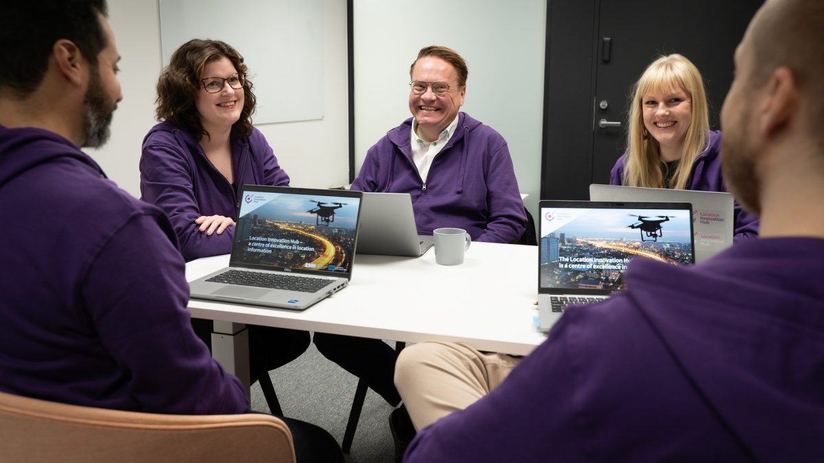 Smiling LIH office staff at the desk wearing purple hoodies.