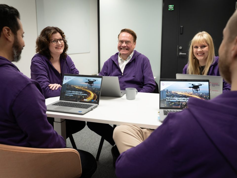 Smiling LIH office staff at the desk wearing purple hoodies.