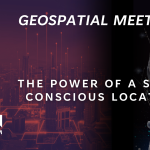 On the dark background, an artificial-looking hand holding a light bulb and a text: Geospatial meets AI: the power of a self-concious location.