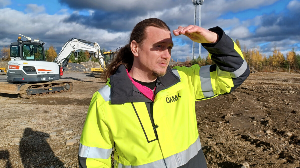 Jaakko Palmunen katselee rakennustyömaata OAMKin keltainen huomiotakki päällä.