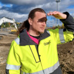 Jaakko Palmunen katselee rakennustyömaata OAMKin keltainen huomiotakki päällä.
