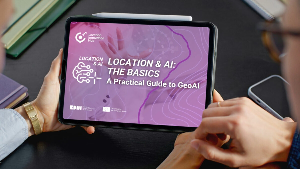 Person holding a tablet displaying the GeoAI guide “Location & AI: The Basics”.